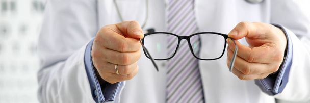 Lékař mužské medicíny ruce dávat pár černých brýlí - Fotografie, Obrázek