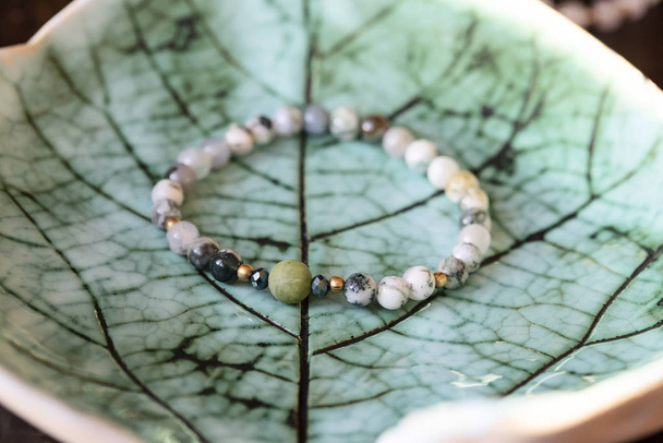 Pietra minerale giada perline minerali braccialetto alla moda su sfondo verde
 - Foto, immagini