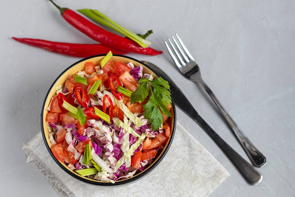 Diät-Salat aus frischem Gemüse. Kohlrabi und Grün, Tomaten, grüne Zwiebeln und Chilischoten schälen. gekleidet mit Olivenöl. - Foto, Bild