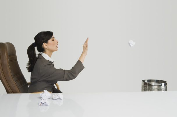 Businesswoman throwing crumpled paper - 写真・画像