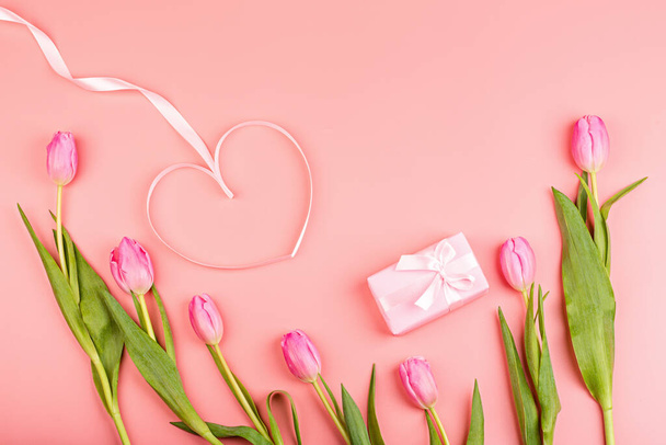 View from above tulips and gift box with copy space. Background for womens day, 8 March. Flat lay style, top view, mockup, template, overhead. Greeting for Womens or Mothers Day. - Foto, Imagem