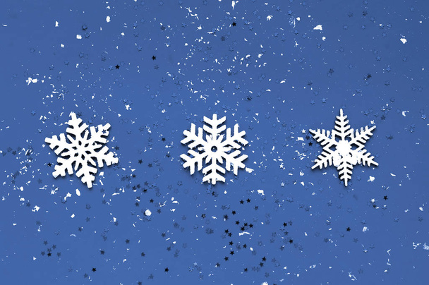 dekorative weiße Weihnachtsdekoration auf klassisch blauem Hintergrund. Muster für die Verpackung von Urlaubspapier. Nahaufnahme - Foto, Bild