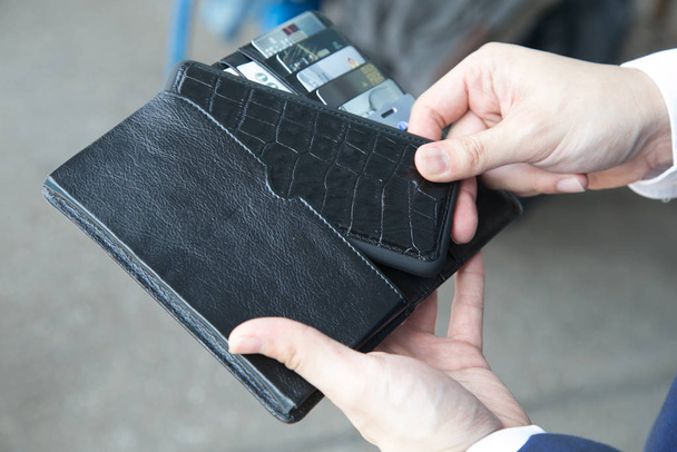 man hands holding wallet with credit cards and stack of money. - 写真・画像