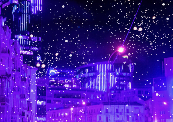 Вечірнє місто в неоновому кольорі зі сніговим тлом.
 - Фото, зображення