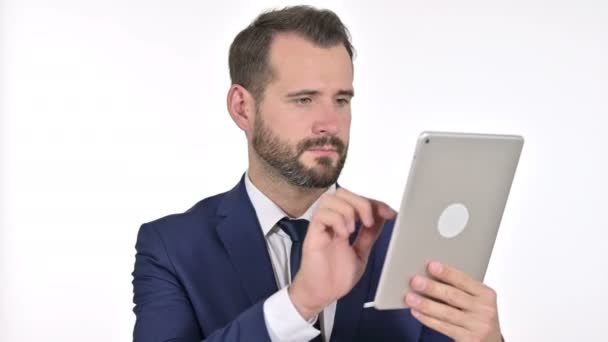 Poważny biznesmen za pomocą tabletu, białe tło - Materiał filmowy, wideo