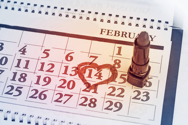 The calendar. He is wearing red lipstick in a black case. February 14th is in a circle. Close-up - Φωτογραφία, εικόνα