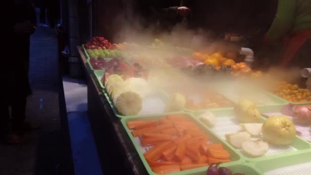 Sliced fruits like grapes, pear, carrot, orange, mandarin, kumquat are selling in a store at The Istiklal Street, Istanbul. Fruits look very fresh when moistened with steam. - Footage, Video