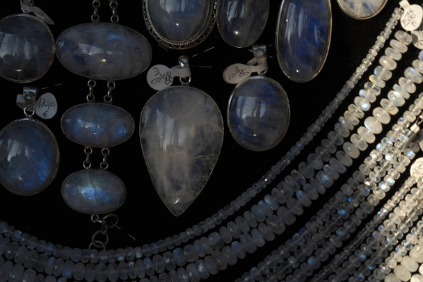 Gökkuşağı ay taşı yaka küpeleri bir mağazanın vitrininde mücevherler. - Fotoğraf, Görsel