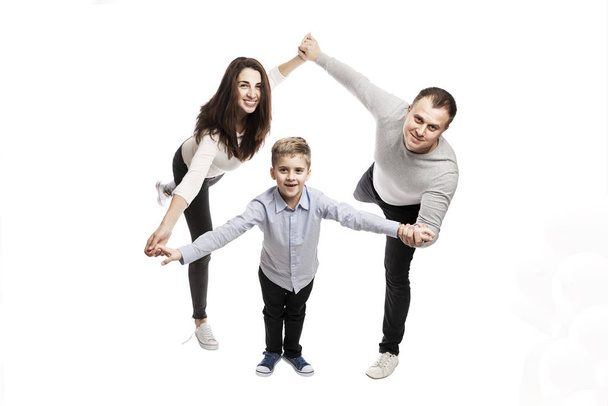 A young family with a son are holding hands and smiling. Love and happiness in the family. Isolated on a white background.  - Fotó, kép