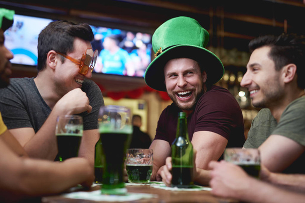 Grupo de homens desfrutando de tempo juntos no pub
 - Foto, Imagem