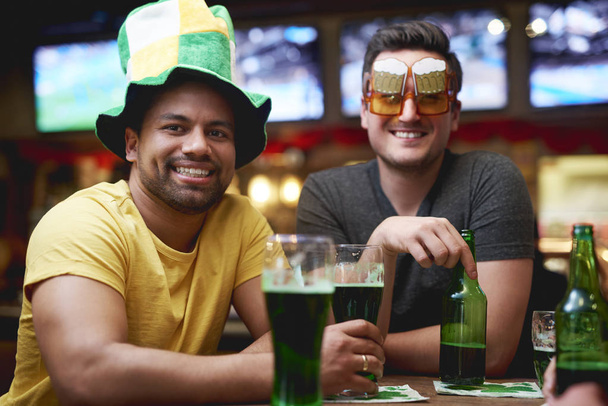 Homens com chapéu de duende e cerveja comemorando o Dia de São Patrício
  - Foto, Imagem