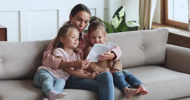 Zorgzame jonge moeder lezen boek knuffel leuke kinderen dochters - Video
