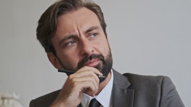 Serious handsome bearded businessman thinking about something and looking away at office - Filmmaterial, Video
