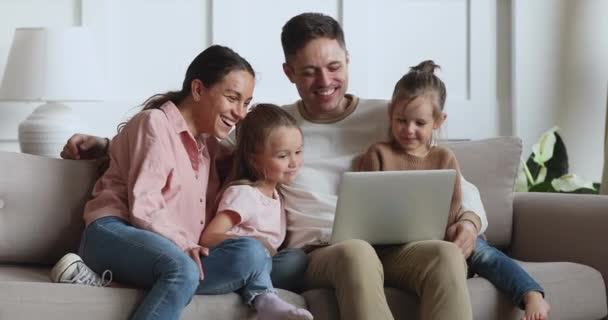 Alegre padres e hijos hijas riendo usando el ordenador portátil en casa
 - Metraje, vídeo