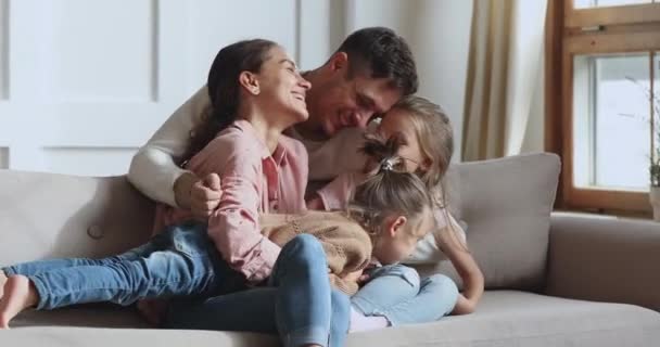 gelukkig liefdevolle familie of vier lachen knuffelen knuffelen op bank - Video