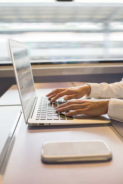 Close-up woman hands typing on a laptop keyboard in the train - 写真・画像