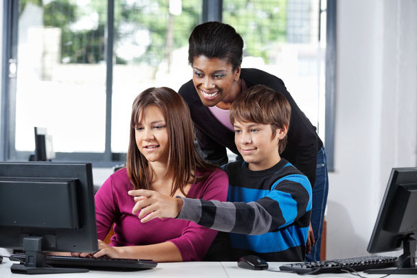 Enseignant aidant les élèves adolescents dans le laboratoire informatique
 - Photo, image