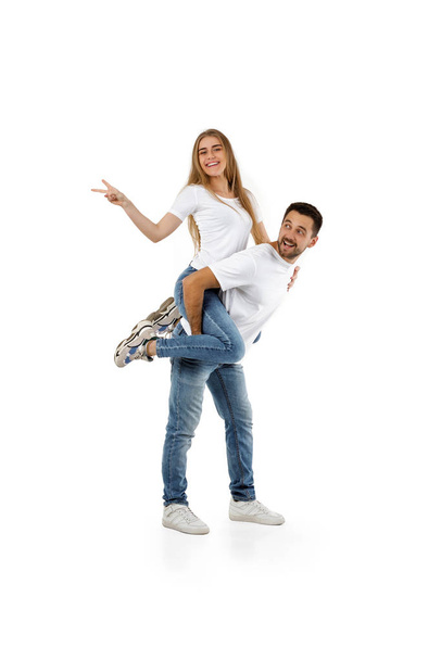 boyfriend giving piggyback to girlfriend on white background - Photo, Image