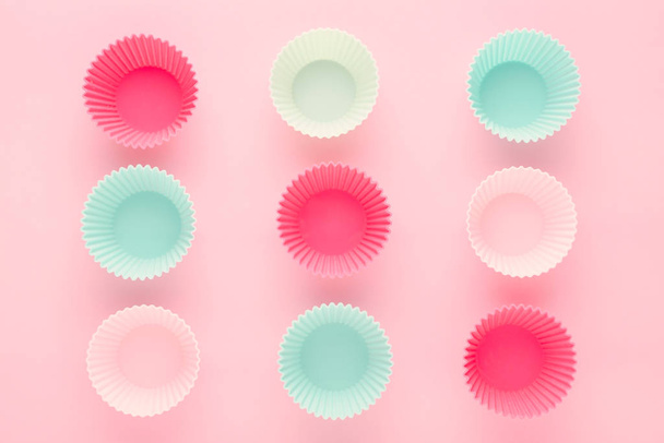 silikoni lomakkeet leivontaan muffinsseja ja cupcakes pastelli vaaleanpunainen tausta
 - Valokuva, kuva