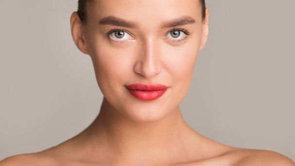 Retrato de belleza de mujer con labios rojos, fondo gris
 - Foto, imagen