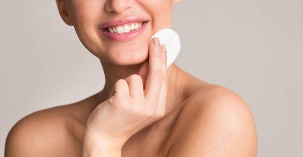 Обычная процедура ухода за кожей. Женщина очищает лицо с помощью тампона
 - Фото, изображение