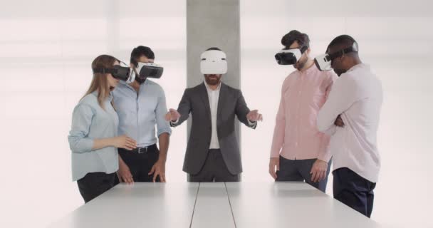 Modern mimari takımı sanal gerçekliği kullanarak kurumsal toplantı yapıyor. Toplantı odasında VR gözlükleriyle çalışan çeşitli iş adamları. İş ve teknoloji kavramı. - Video, Çekim