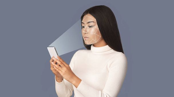 biometrische Verifizierung. Mädchen mit Smartphone mit Gesichtserkennung - Foto, Bild