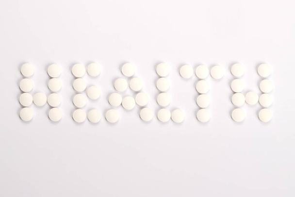 Word Health made from white tablets on the white background - Foto, Imagem