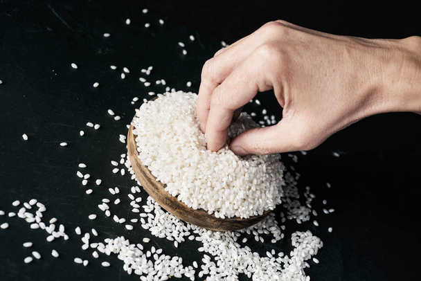 hombre agarrando algunos granos de arroz
 - Foto, imagen
