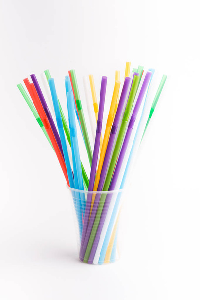 Пластиковые соломинки для питья внутри пластиковой чашки изолированы на белом
 - Фото, изображение
