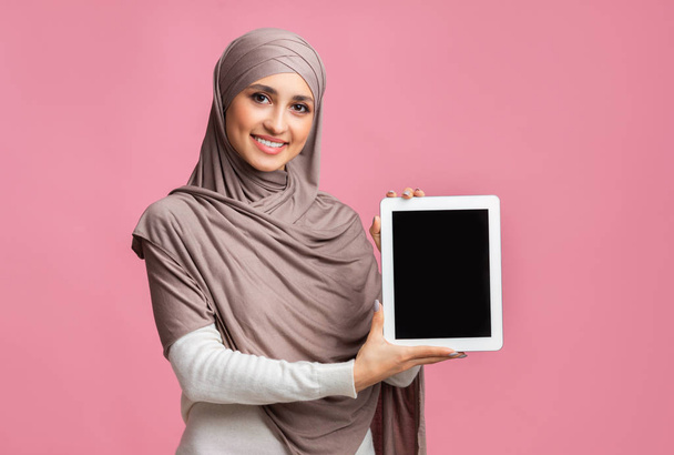 Chica musulmana en Hijab mostrando tableta digital con pantalla negra en blanco
 - Foto, imagen