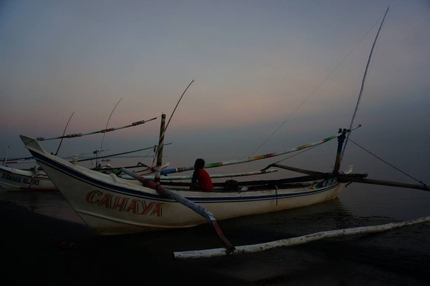 Tradycyjne statki rybackie, które nadal korzystają z tradycyjnych narzędzi połowowych, łódź ta wykonana jest z drewna odpornego na wodę morską. Przystań dla łodzi rybackich na wybrzeżu. - Zdjęcie, obraz