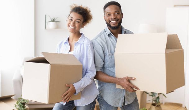 Young Couple Carrying Moving Boxes Into New House - Foto, Imagen