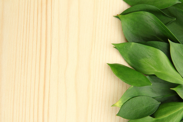 beautiful green leaves, on wooden background - Photo, Image