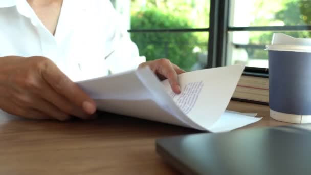4k video di primo piano uomo d'affari gira pagina di lettura a mano e rivedere il documento cartaceo scritto facendo note errore corretto in ufficio
. - Filmati, video