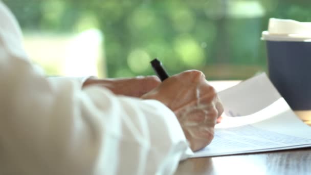 4k-Video von Nahaufnahme Geschäftsmann blättert Seite von Hand lesen und überarbeiten Sie das schriftliche Papier Dokument machen Notizen Fehler richtig im Büro. - Filmmaterial, Video