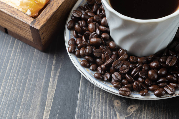 Tasse heißen Kaffee und geröstete Kaffeebohnen - Foto, Bild