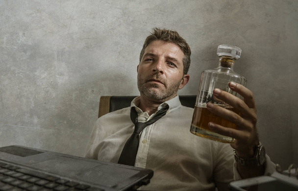 alcolizzato uomo d'affari drammatico ritratto di uomo alcolizzato in perdere cravatta bere alla scrivania mentre si lavora sprecato e disordinato in possesso di bottiglia di whisky ubriaco e depresso
 - Foto, immagini