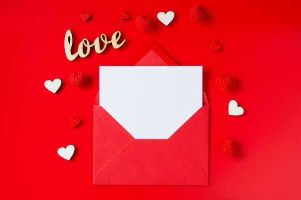 Tarjeta de felicitación de San Valentín. Sobre rojo con tarjeta en blanco. Vista superior con espacio para tus saludos
. - Foto, Imagen