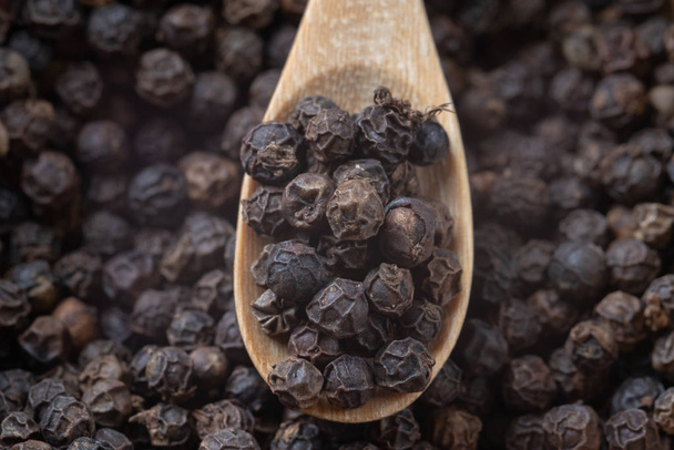 close up of pile black pepper and wooden spoon - Φωτογραφία, εικόνα