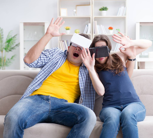 Genç bir aile sanal gerçeklik gözlükleriyle oyun oynuyor. - Fotoğraf, Görsel