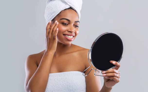 Mujer bonita mirando su cara en el espejo después de la ducha
 - Foto, Imagen