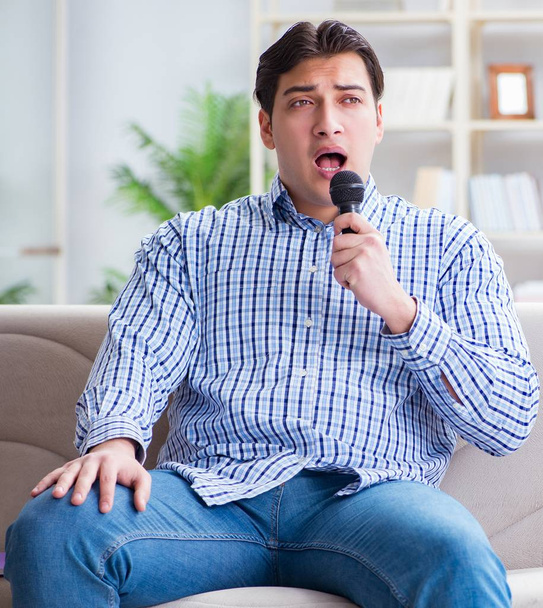 Забавный человек поет песни в караоке дома - Фото, изображение