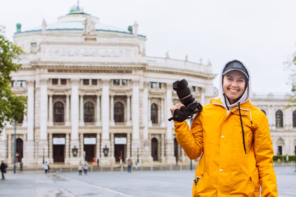 giovane bella donna fotografo con fotocamera professionale di fronte al vecchio edificio dell'opera
 - Foto, immagini