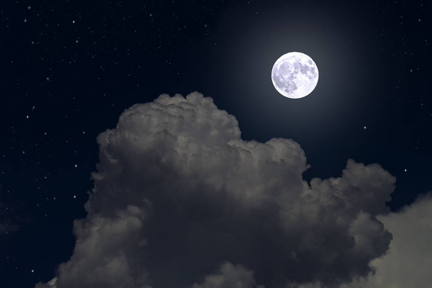 La luna llena entre las nubes en el cielo nocturno
 - Foto, Imagen