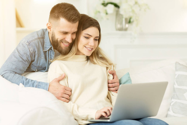 Millennial pareja web de surf en el ordenador portátil en casa
 - Foto, imagen