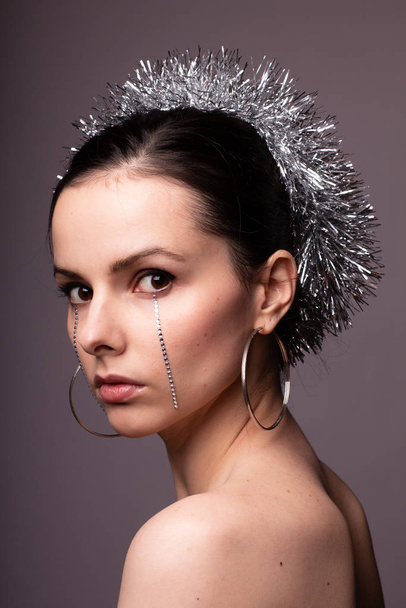 beautiful girl in a brilliant rim with rhinestones on her face - Foto, imagen