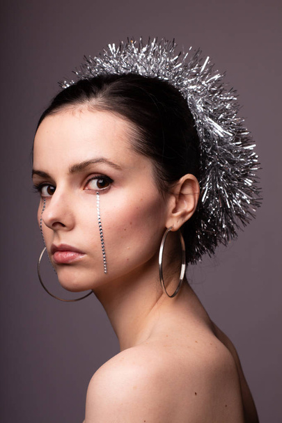 beautiful girl in a brilliant rim with rhinestones on her face - 写真・画像