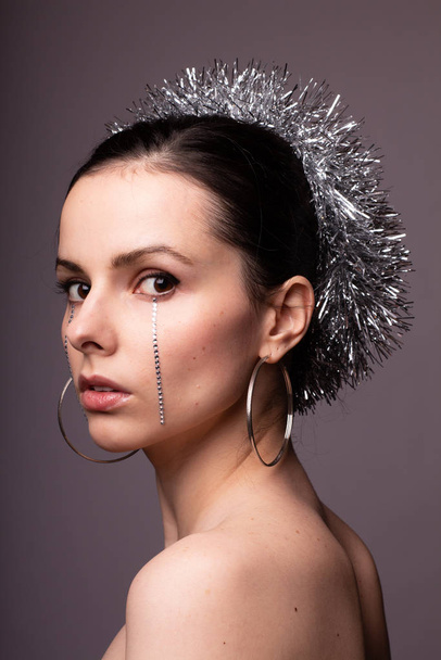 beautiful girl in a brilliant rim with rhinestones on her face - Foto, Imagem
