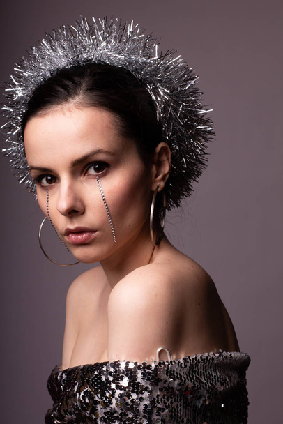 beautiful girl in a best-looking dress, a brilliant rim with rhinestones on her face - 写真・画像